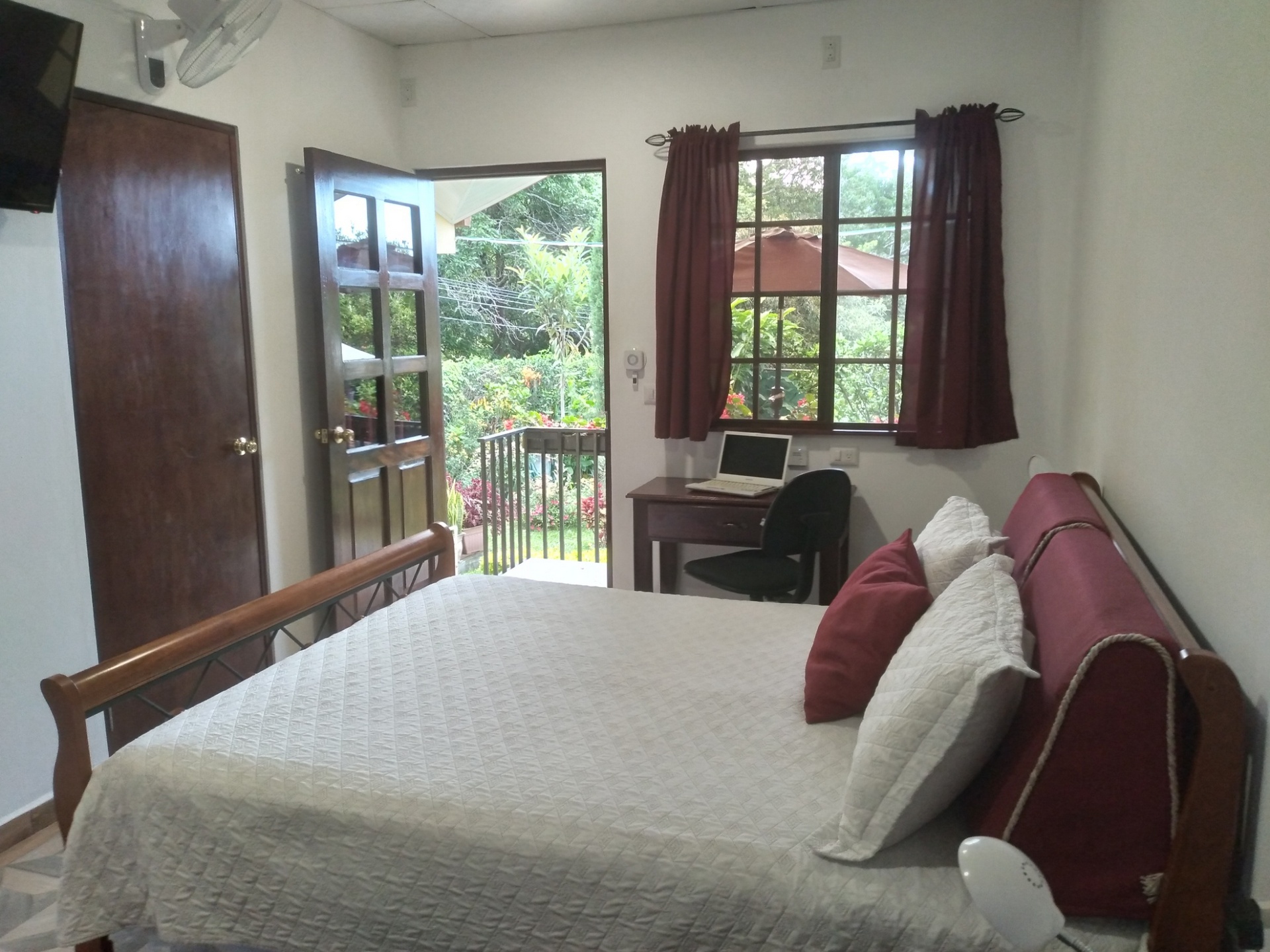 A bedroom at Aparthotel Boquete with an open door leading to the private terrace